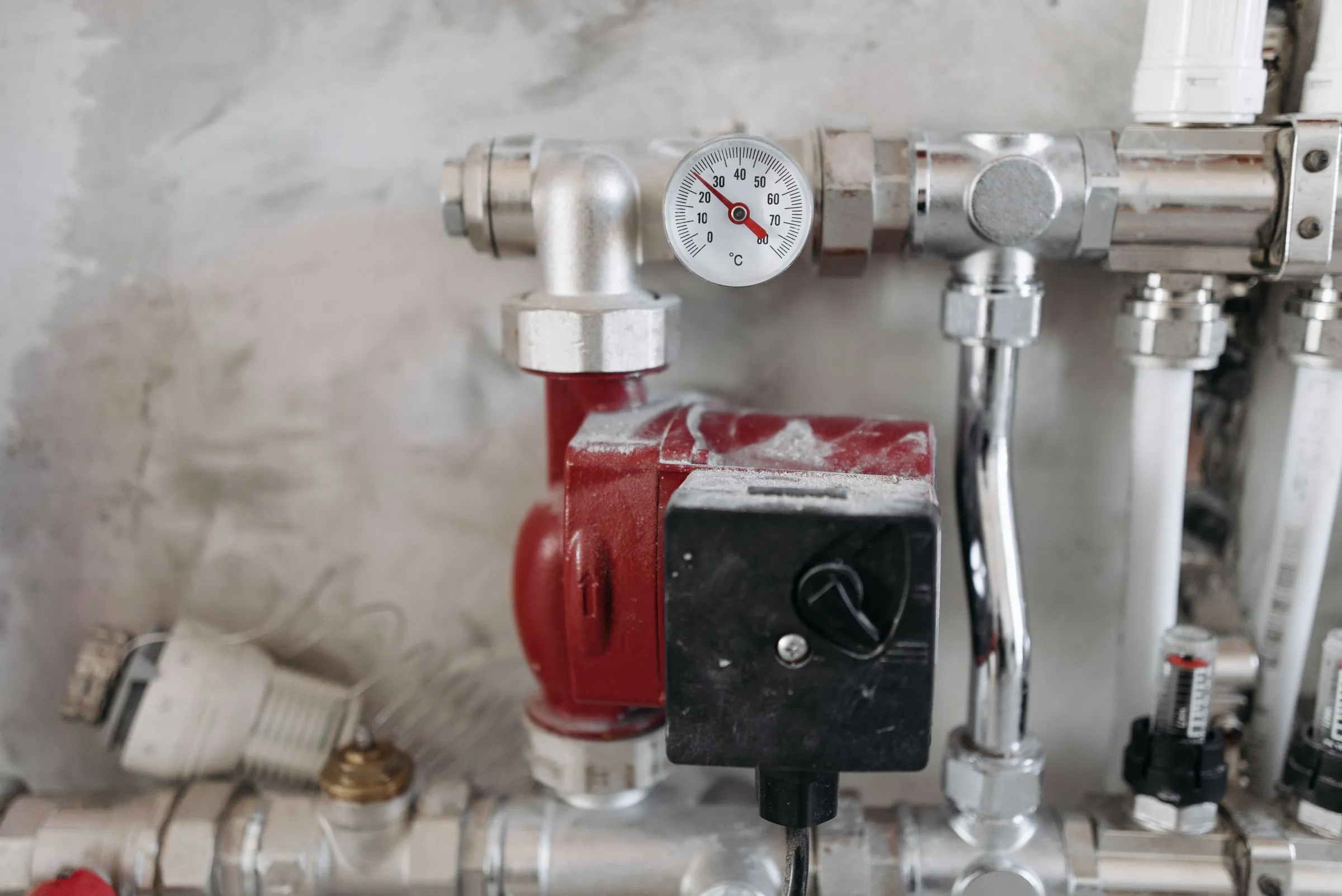 A heating manifold with a pressure gauge and circulating pump, freshly serviced